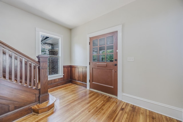 5532 Reiger Ave, Dallas, TX 75214 - foyer entrance featuring light wood-type flooring, healthy amount of natural light, a wainscoted wall, stairs, and baseboards