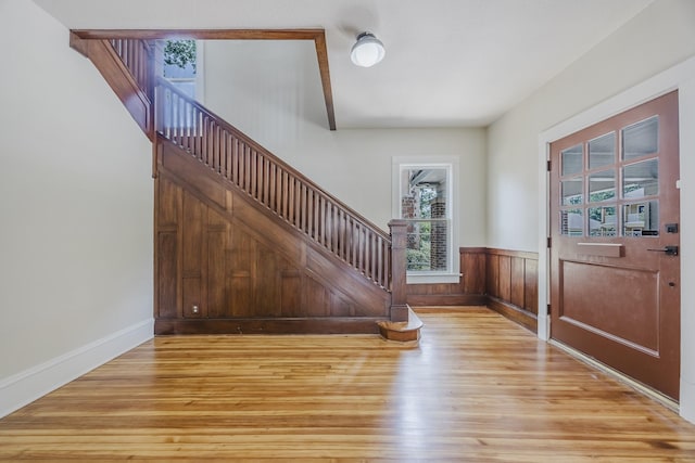 5532 Reiger Ave, Dallas, TX 75214 - entrance foyer with light wood-style floors, stairs, baseboards, and a wainscoted wall