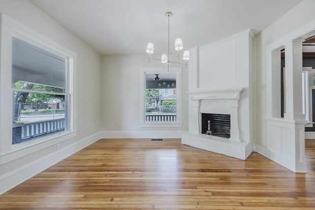 5532 Reiger Ave, Dallas, TX 75214 - unfurnished living room with light wood-style flooring, a chandelier, a fireplace, and baseboards