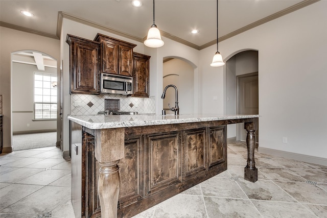 3009 Guadalupe Dr, Forney, TX 75126 - kitchen with stainless steel microwave, arched walkways, baseboards, dark brown cabinets, and tasteful backsplash