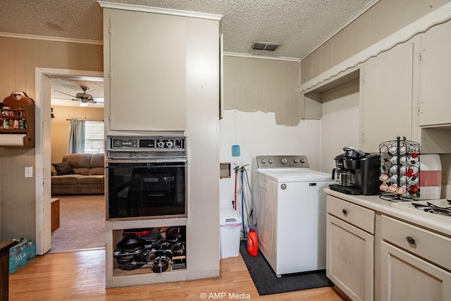 1302 6th St, Anson, TX 79501 - laundry area featuring washer / dryer, a textured ceiling, ornamental molding, light wood-type flooring, and a ceiling fan
