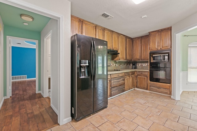 124 Bent Tree Trl, Burleson, TX 76028 - kitchen featuring black appliances, light countertops, brown cabinetry, baseboards, and decorative backsplash