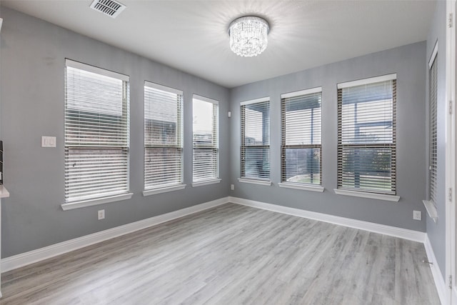 716 Field Xing, Little Elm, TX 76227 - empty room featuring a chandelier, healthy amount of natural light, wood finished floors, and baseboards