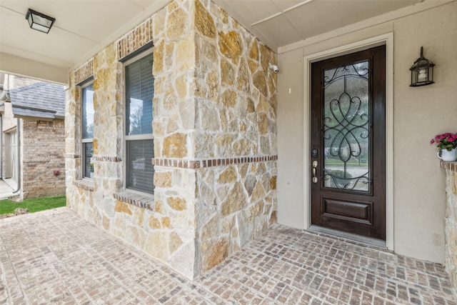 716 Field Xing, Little Elm, TX 76227 - doorway to property featuring stone siding and covered porch