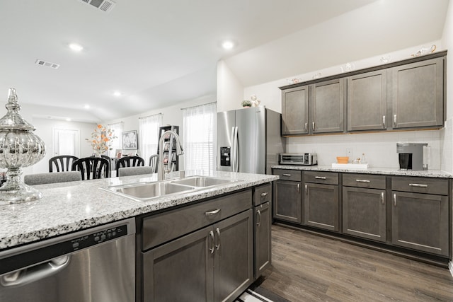 107 Alydar Ln, Caddo Mills, TX 75135 - kitchen featuring appliances with stainless steel finishes, a sink, dark wood finished floors, tasteful backsplash, and light stone countertops