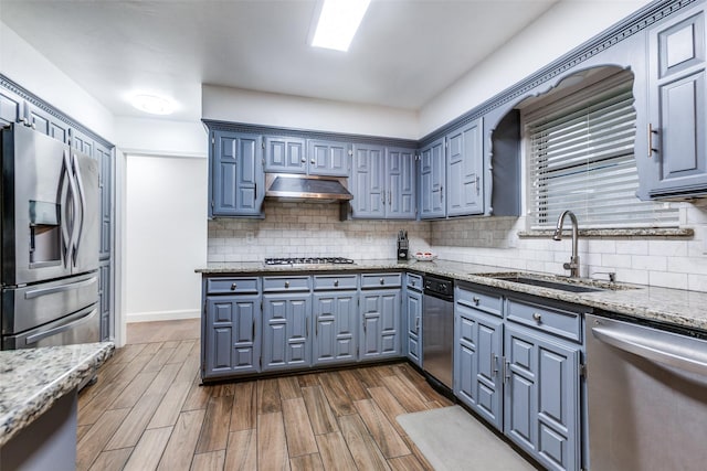 10220 Shadow Way, Dallas, TX 75243 - kitchen with appliances with stainless steel finishes, a sink, under cabinet range hood, tasteful backsplash, and dark wood-style flooring