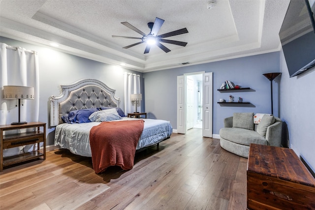 10220 Shadow Way, Dallas, TX 75243 - bedroom with a raised ceiling, light wood finished floors, a textured ceiling, ornamental molding, and ceiling fan