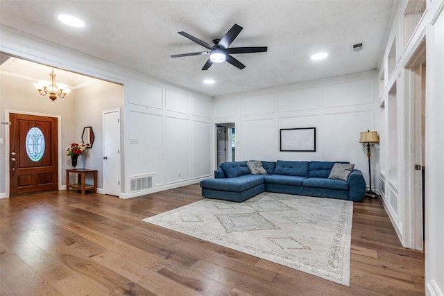 10220 Shadow Way, Dallas, TX 75243 - living area with a chandelier, a decorative wall, ceiling fan, crown molding, and wood finished floors