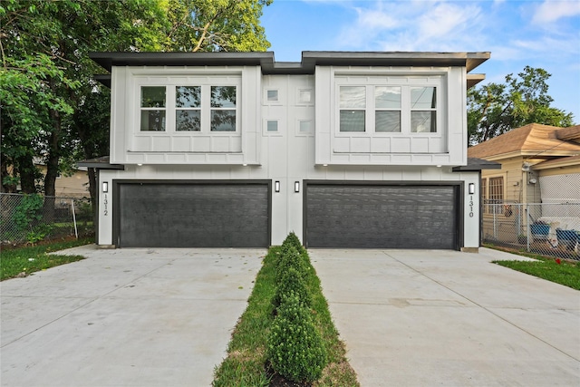 1310 Coleman Ave, Dallas, TX 75215 - view of front of home featuring an attached garage, concrete driveway, and board and batten siding