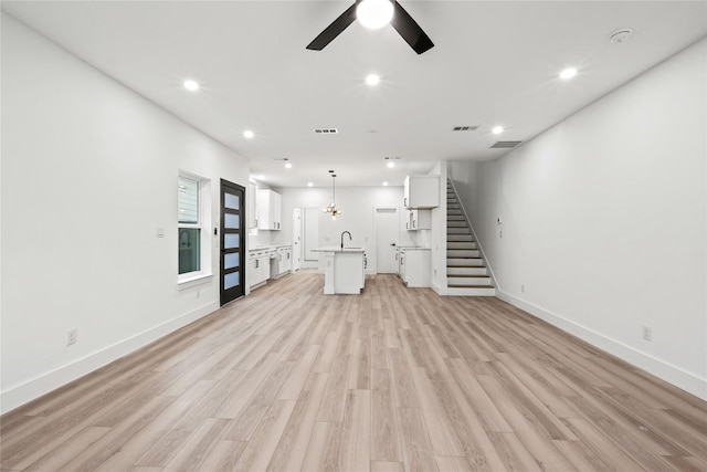 1310 Coleman Ave, Dallas, TX 75215 - unfurnished living room featuring a sink, recessed lighting, ceiling fan, stairway, and light wood finished floors