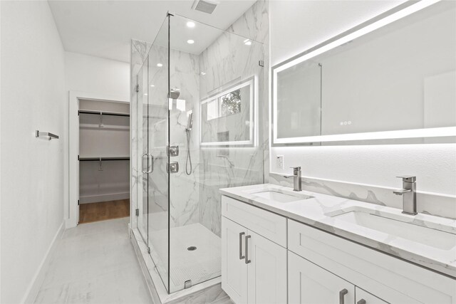 1310 Coleman Ave, Dallas, TX 75215 - bathroom featuring a marble finish shower, baseboards, double vanity, and a walk in closet