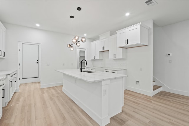 1310 Coleman Ave, Dallas, TX 75215 - kitchen featuring a sink, decorative backsplash, light wood finished floors, a center island with sink, and recessed lighting