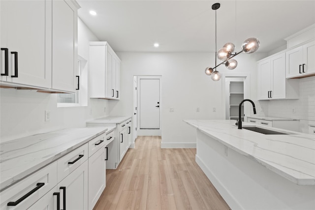 1310 Coleman Ave, Dallas, TX 75215 - kitchen featuring a sink, backsplash, light wood-style floors, white cabinets, and recessed lighting