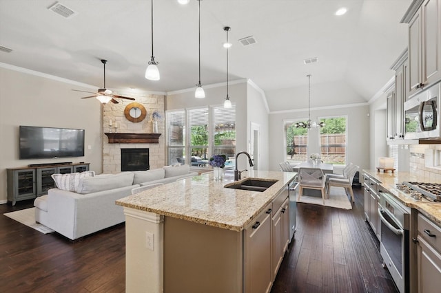 14513 Mediterranean Dr, Frisco, TX 75035 - kitchen with a sink, a stone fireplace, appliances with stainless steel finishes, ceiling fan, and ornamental molding