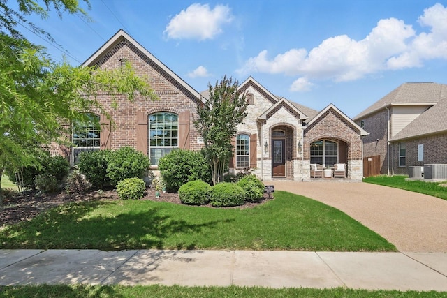 14513 Mediterranean Dr, Frisco, TX 75035 - french country home with stone siding, brick siding, a front lawn, and central air condition unit