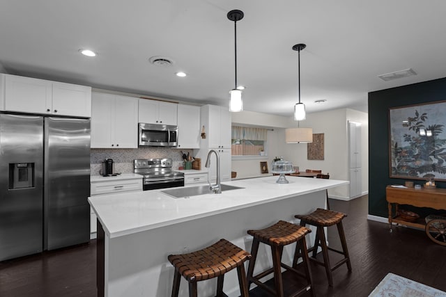 2512 Buckingham Dr, Denton, TX 76209 - kitchen with stainless steel appliances, a sink, dark wood finished floors, white cabinetry, and recessed lighting