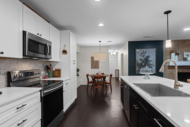 2512 Buckingham Dr, Denton, TX 76209 - kitchen with appliances with stainless steel finishes, a sink, light countertops, white cabinets, and dark wood-type flooring