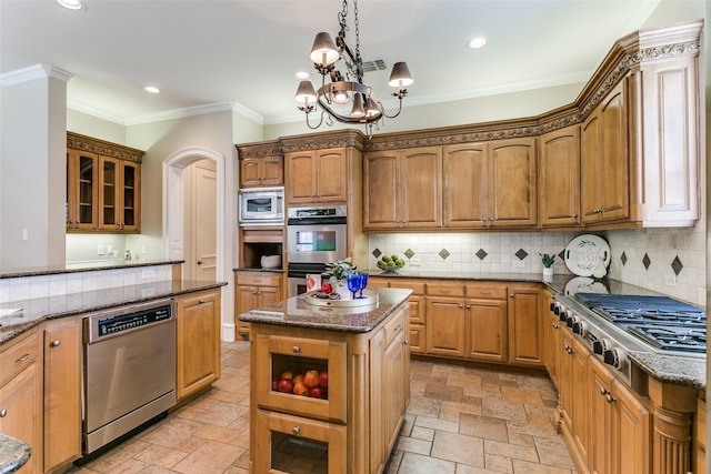 2313 Ember Woods Dr, Keller, TX 76262 - kitchen with appliances with stainless steel finishes, stone tile flooring, dark stone counters, crown molding, and decorative backsplash