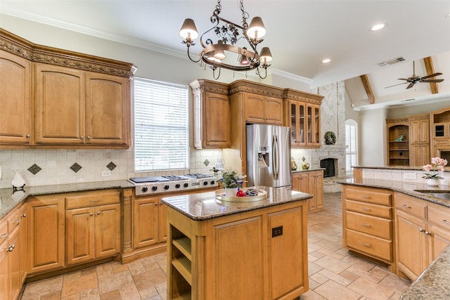 2313 Ember Woods Dr, Keller, TX 76262 - kitchen featuring appliances with stainless steel finishes, a fireplace, ceiling fan, stone countertops, and decorative backsplash