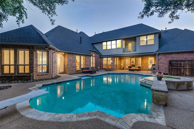 2313 Ember Woods Dr, Keller, TX 76262 - pool at dusk with a patio, a pool with connected hot tub, and a diving board