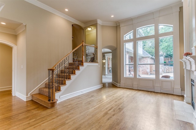 2313 Ember Woods Dr, Keller, TX 76262 - entrance foyer featuring arched walkways, wood finished floors, ornamental molding, stairs, and recessed lighting