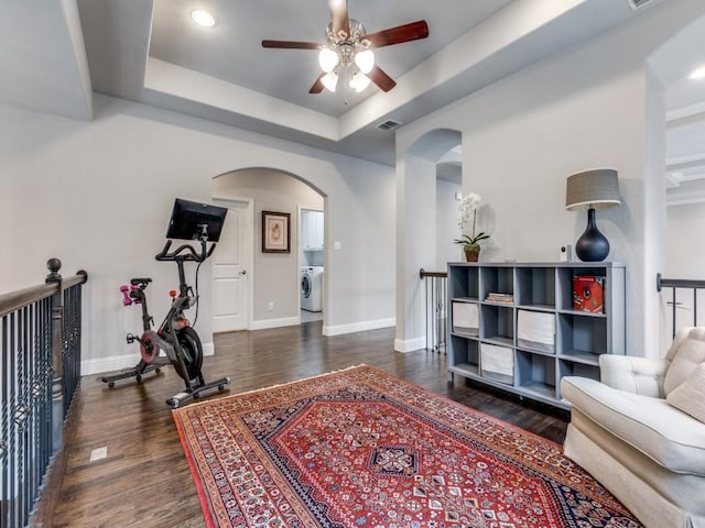 916 Shadyside Ln, Dallas, TX 75223 - exercise area featuring arched walkways, washer / dryer, a ceiling fan, wood finished floors, and baseboards
