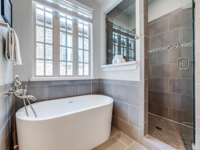 916 Shadyside Ln, Dallas, TX 75223 - bathroom with tile walls, a shower stall, a freestanding bath, tile patterned flooring, and wainscoting