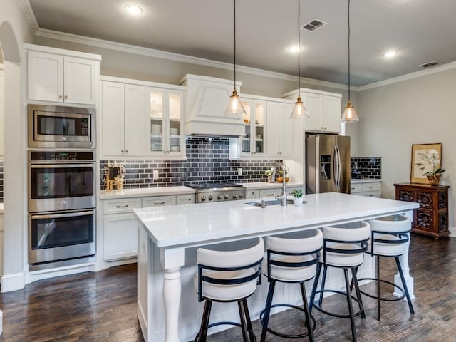 916 Shadyside Ln, Dallas, TX 75223 - kitchen with appliances with stainless steel finishes, a sink, an island with sink, tasteful backsplash, and a kitchen bar