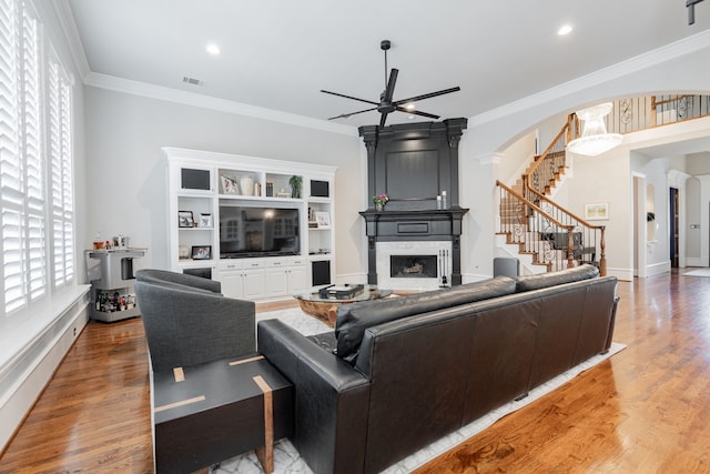13 Kensington Dr, Heath, TX 75032 - living area featuring a large fireplace, a ceiling fan, stairway, arched walkways, and crown molding