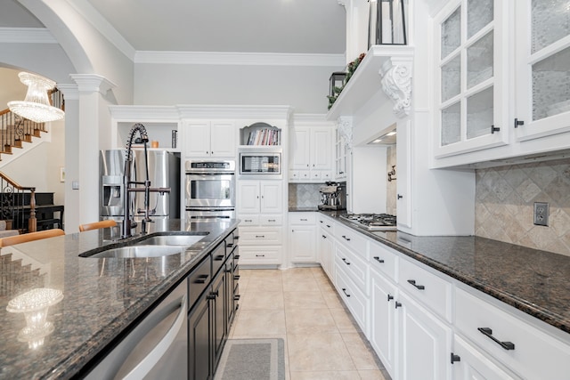 13 Kensington Dr, Heath, TX 75032 - kitchen with arched walkways, appliances with stainless steel finishes, ornate columns, white cabinets, and crown molding