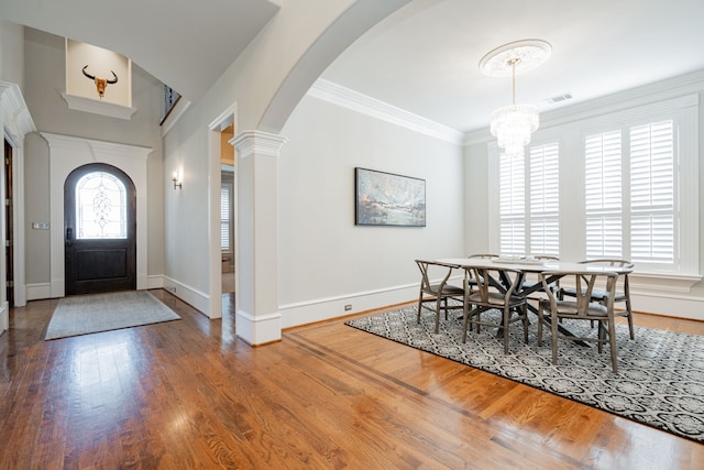 13 Kensington Dr, Heath, TX 75032 - dining area with arched walkways, baseboards, wood finished floors, ornamental molding, and a chandelier