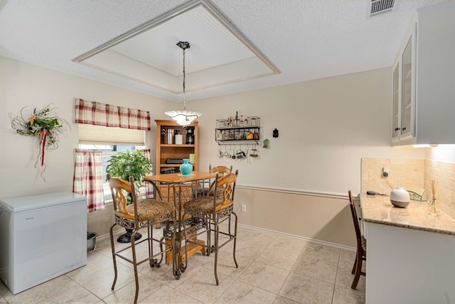 10253 Fieldcrest Dr, Benbrook, TX 76126 - dining area with a tray ceiling, light tile patterned floors, and baseboards