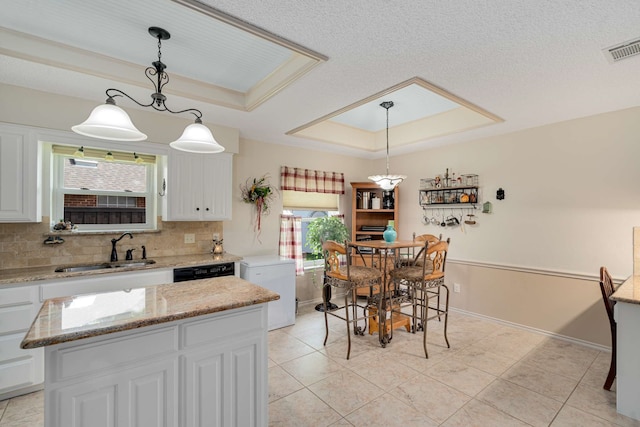10253 Fieldcrest Dr, Benbrook, TX 76126 - kitchen featuring a sink, a raised ceiling, white cabinetry, tasteful backsplash, and a kitchen island