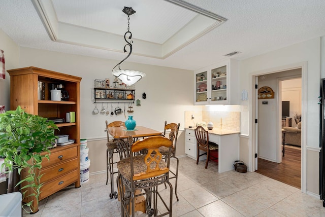 10253 Fieldcrest Dr, Benbrook, TX 76126 - dining area featuring light tile patterned flooring, a textured ceiling, and a tray ceiling