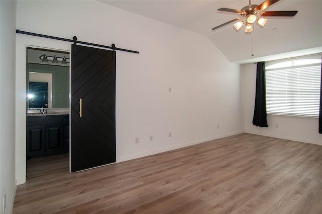 1928 Argyle Ln, Lewisville, TX 75067 - unfurnished room featuring a ceiling fan, light wood finished floors, a barn door, vaulted ceiling, and a sink