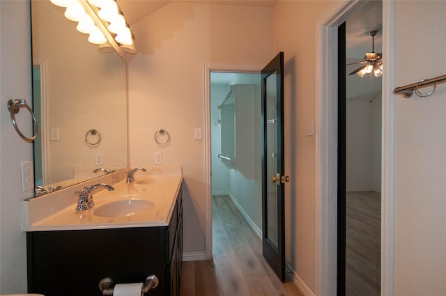 1928 Argyle Ln, Lewisville, TX 75067 - bathroom featuring wood finished floors, double vanity, a chandelier, baseboards, and a ceiling fan