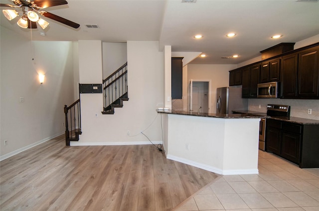 1928 Argyle Ln, Lewisville, TX 75067 - kitchen with appliances with stainless steel finishes, dark stone counters, ceiling fan, light wood finished floors, and recessed lighting