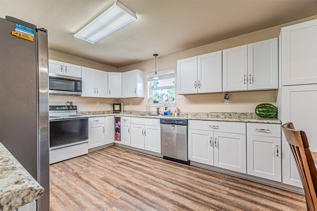 400 Rs County Road 3130, Emory, TX 75440 - kitchen featuring stainless steel appliances, light wood-style floors, white cabinetry, hanging light fixtures, and light stone counters