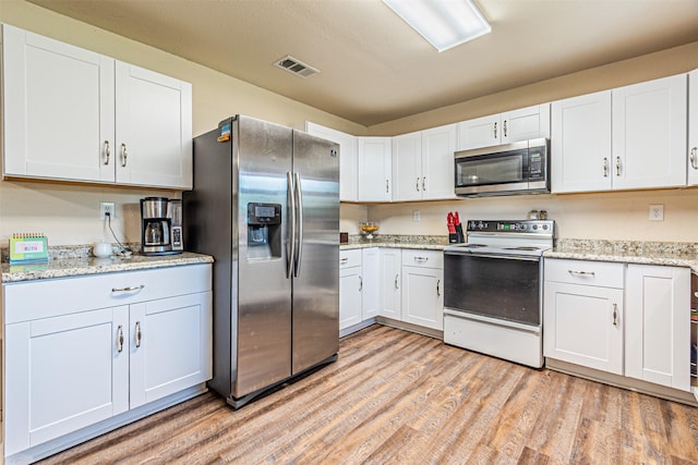 400 Rs County Road 3130, Emory, TX 75440 - kitchen featuring stainless steel appliances, light wood-type flooring, white cabinetry, and light stone countertops
