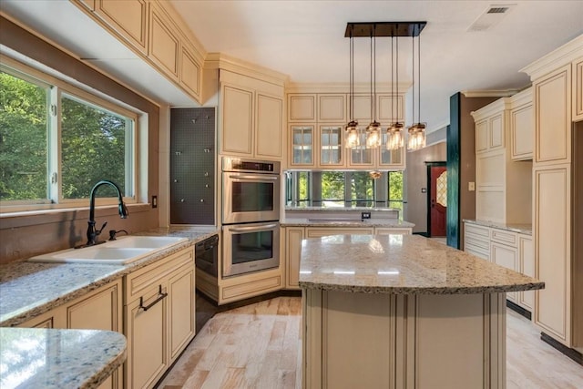 4291 County Road 862, Mckinney, TX 75071 - kitchen featuring cream cabinetry, double oven, a sink, a kitchen island, and light wood finished floors
