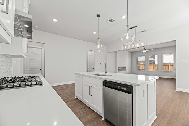 16532 Dunkirk Ln, Frisco, TX 75035 - kitchen with stainless steel appliances, a sink, ceiling fan, light countertops, and wood finished floors