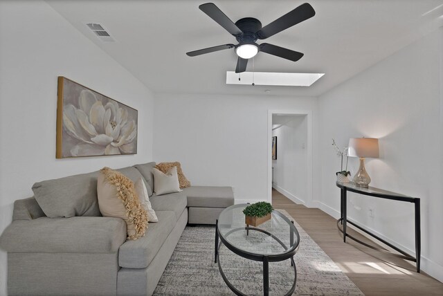 6928 Glen Hills Rd, Richland Hills, TX 76118 - living area with a skylight, ceiling fan, wood finished floors, and baseboards