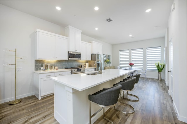 2734 Levee Ln, Lewisville, TX 75067 - kitchen with a sink, stainless steel appliances, decorative backsplash, an island with sink, and baseboards