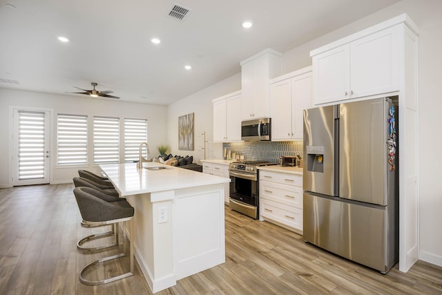 2734 Levee Ln, Lewisville, TX 75067 - kitchen with stainless steel appliances, a sink, ceiling fan, light countertops, and white cabinets
