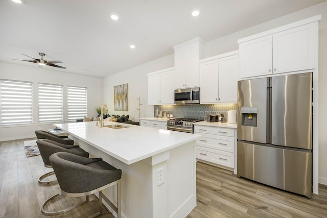 2734 Levee Ln, Lewisville, TX 75067 - kitchen with appliances with stainless steel finishes, a sink, backsplash, white cabinetry, and recessed lighting