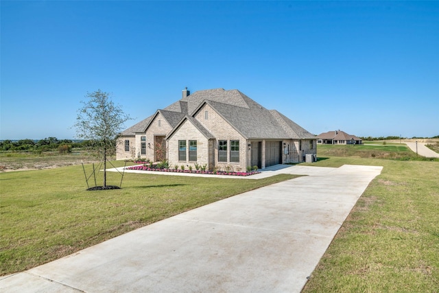 9900 Aiken Ct, Mesquite, TX 75126 - french country style house with concrete driveway, an attached garage, a chimney, a front yard, and brick siding