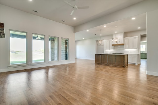 9900 Aiken Ct, Mesquite, TX 75126 - unfurnished living room featuring a ceiling fan, a sink, light wood-style floors, baseboards, and recessed lighting