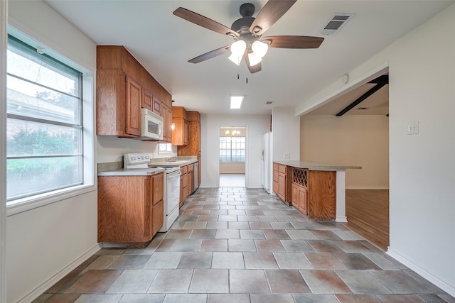 4313 Barcelona Dr, Fort Worth, TX 76133 - kitchen with white appliances, brown cabinets, baseboards, and light countertops
