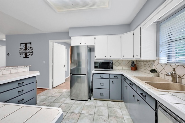 116 Modoc Trl, Lake Kiowa, TX 76240 - kitchen featuring appliances with stainless steel finishes, a sink, gray cabinets, and decorative backsplash