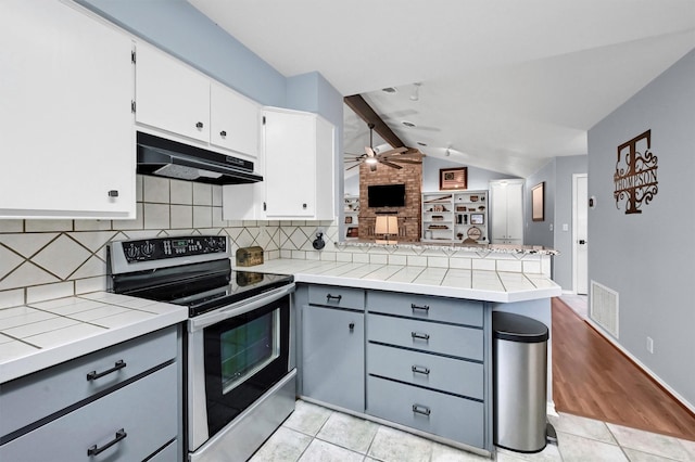 116 Modoc Trl, Lake Kiowa, TX 76240 - kitchen with stainless steel electric stove, under cabinet range hood, a peninsula, gray cabinets, and backsplash